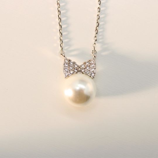 Pearl Bowtie Charm Necklace in White Gold Color Front Close Up